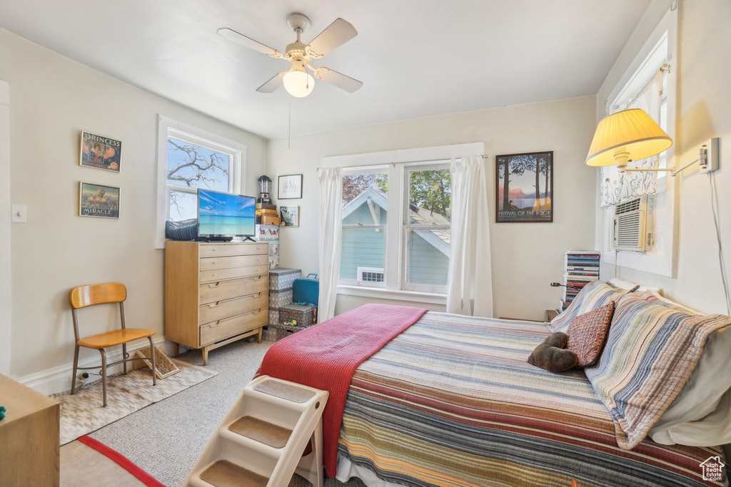 Bedroom featuring carpet floors, multiple windows, ceiling fan, and baseboards