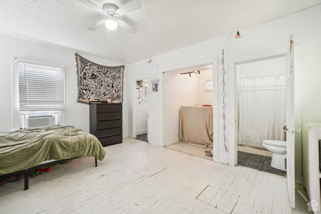 Bedroom featuring cooling unit, connected bathroom, and wood finished floors