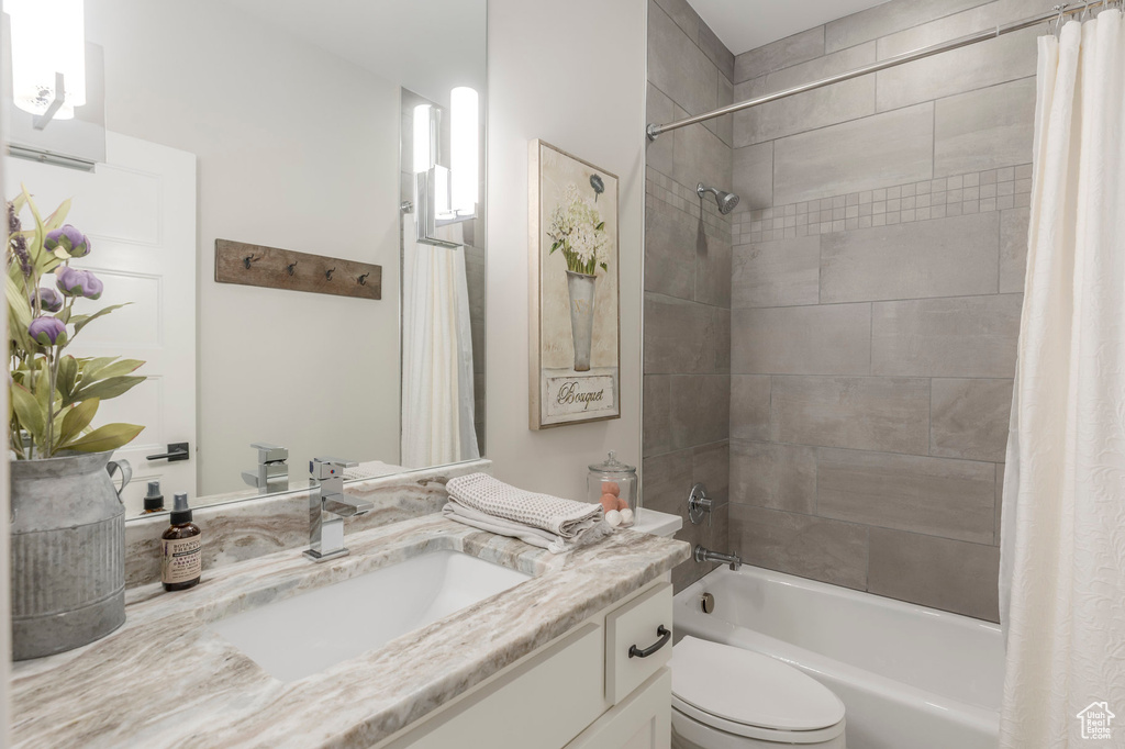 Bathroom featuring shower / tub combo, vanity, and toilet