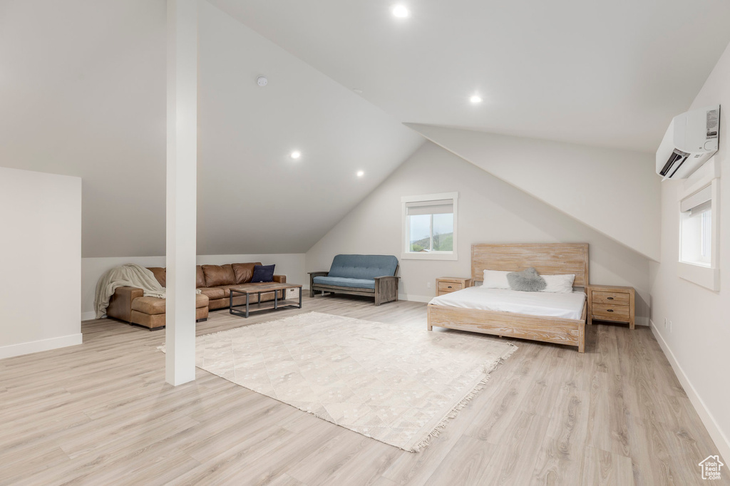 Bedroom with a wall unit AC, light wood-style floors, lofted ceiling, baseboards, and recessed lighting