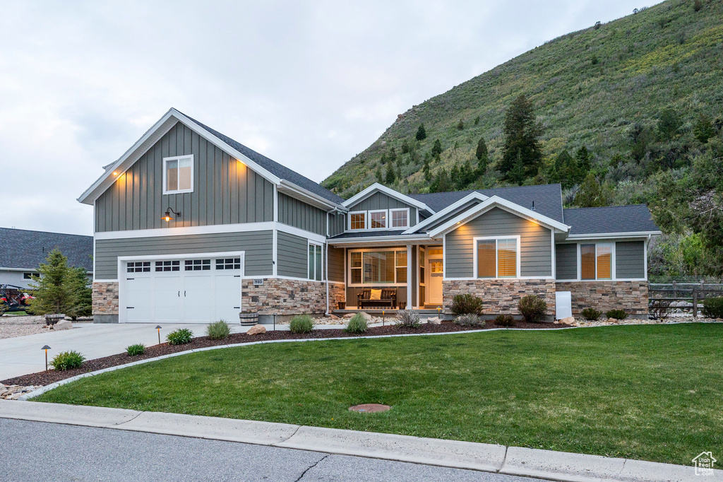 Craftsman inspired home with covered porch, stone siding, board and batten siding, and a mountain view