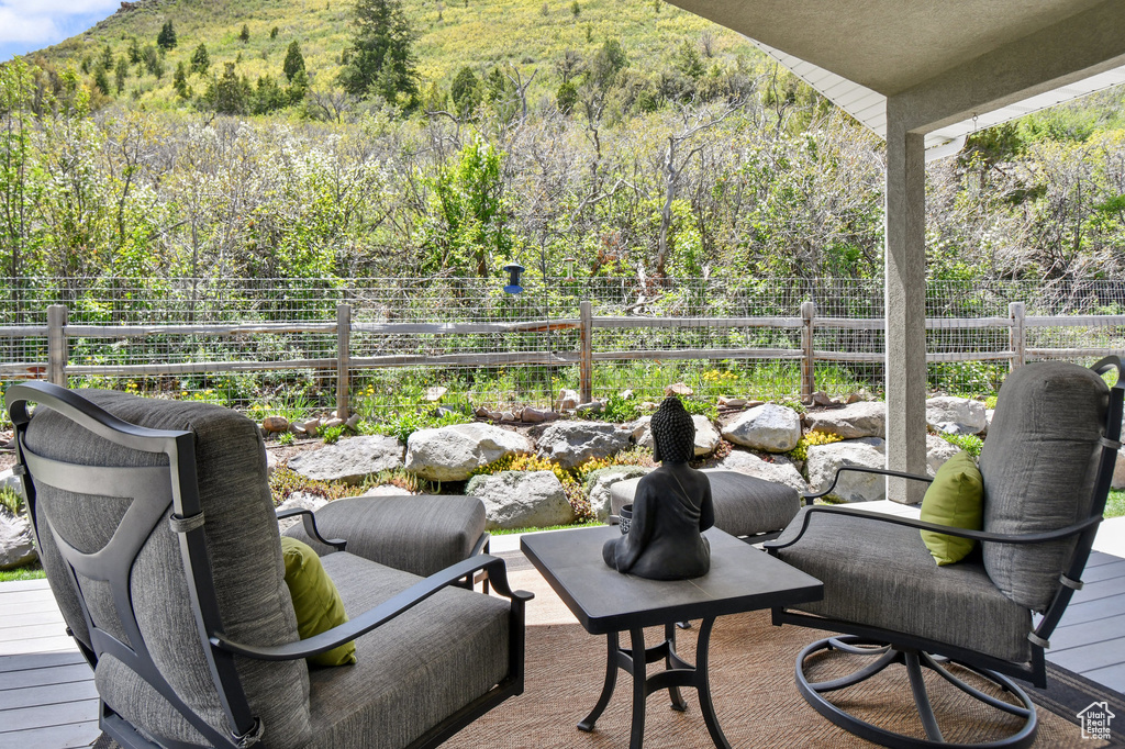 View of patio / terrace featuring fence, a mountain view, and a forest view