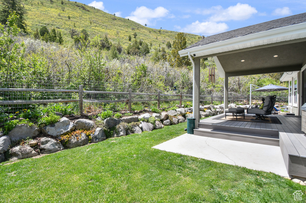 View of yard featuring a deck with mountain view and an outdoor hangout area