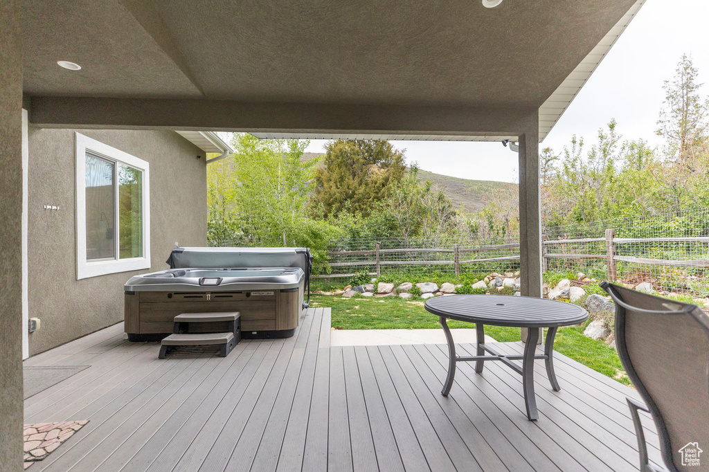 Deck featuring a hot tub, a fenced backyard, and a mountain view