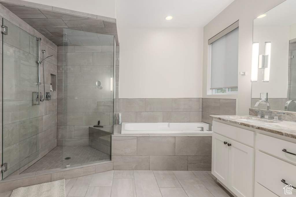 Bathroom featuring a bath, a stall shower, vanity, tile patterned flooring, and recessed lighting