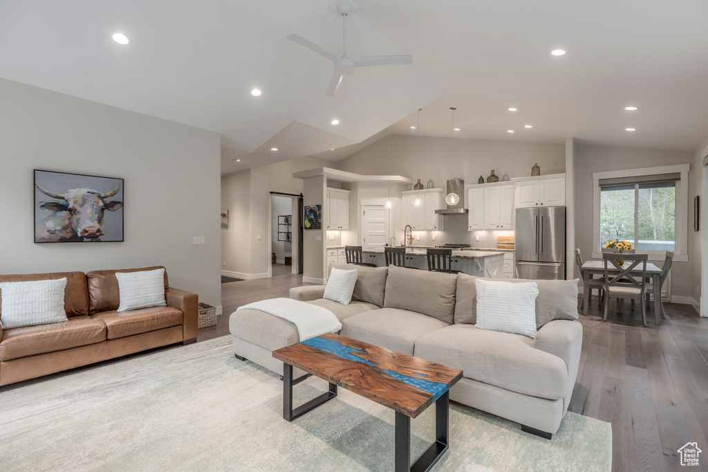 Living area featuring lofted ceiling, light wood finished floors, recessed lighting, a ceiling fan, and baseboards