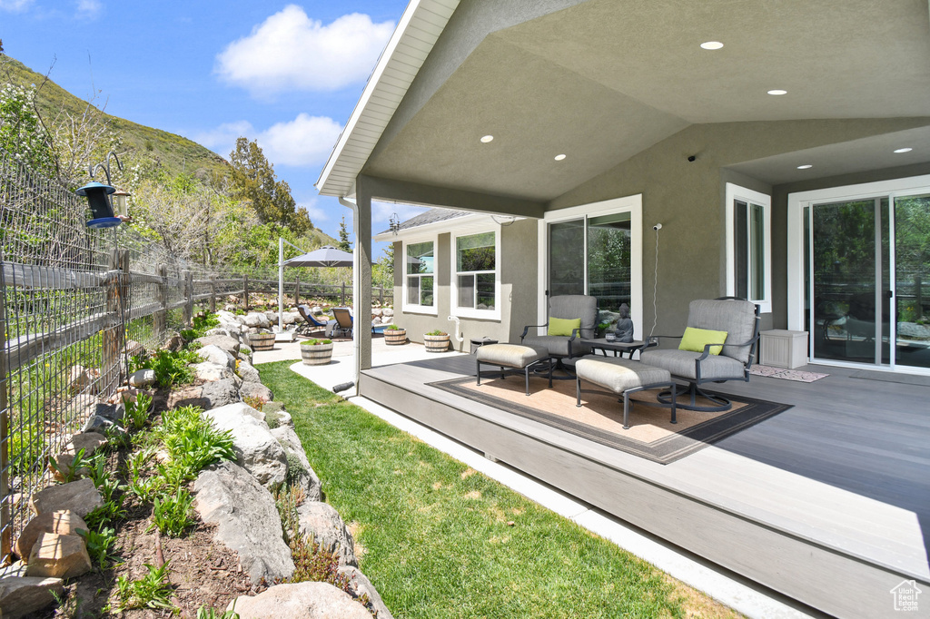 View of patio / terrace with an outdoor hangout area, fence, and a deck with mountain view