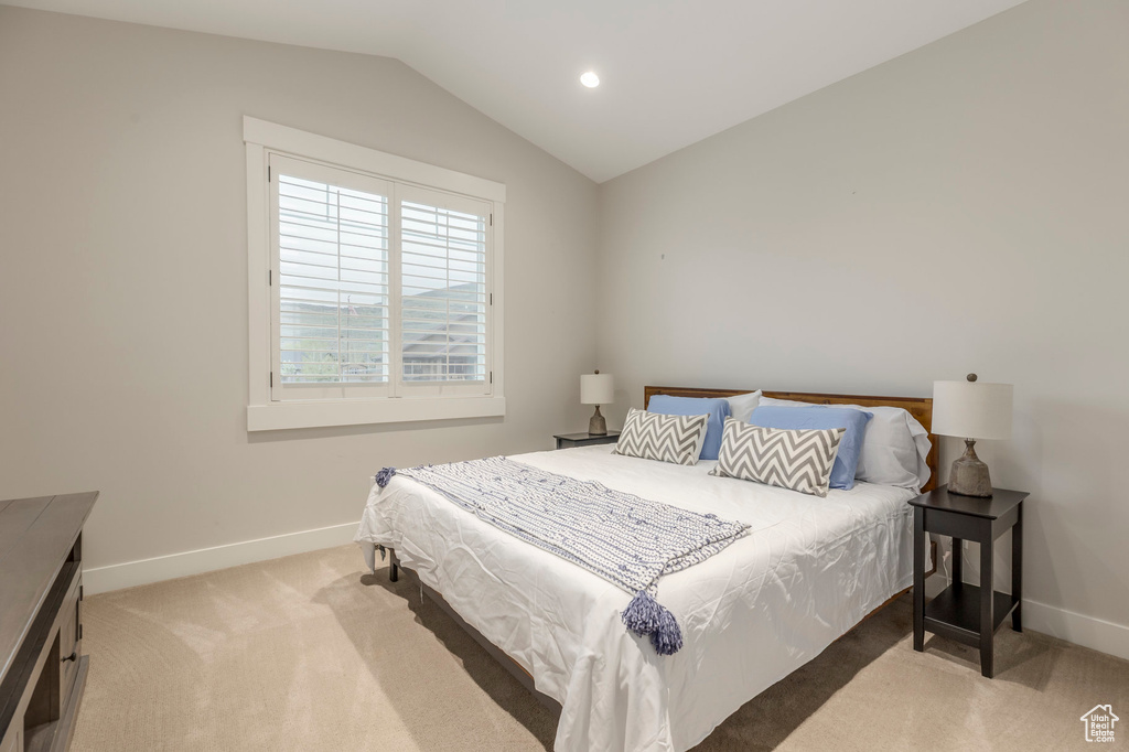 Bedroom with light carpet, vaulted ceiling, baseboards, and recessed lighting