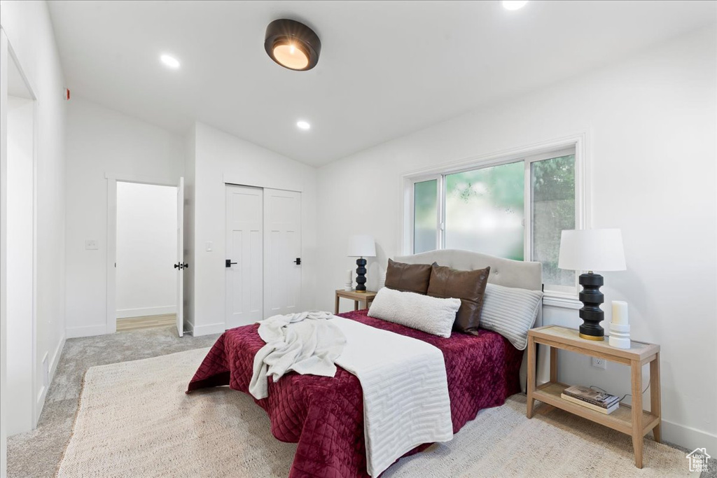 Bedroom featuring lofted ceiling, a closet, recessed lighting, and baseboards