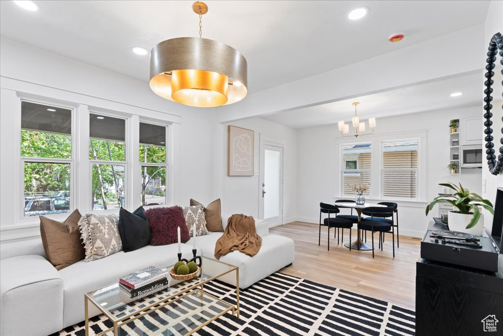 Living area with a chandelier, light wood finished floors, recessed lighting, and baseboards