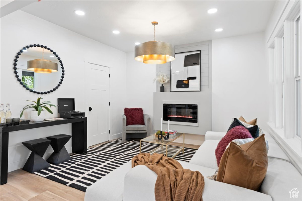 Living area with recessed lighting, wood finished floors, and a large fireplace