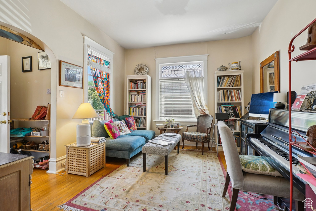 Home office with arched walkways and wood finished floors
