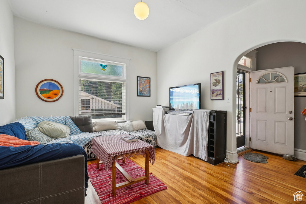 Living area with arched walkways and wood finished floors