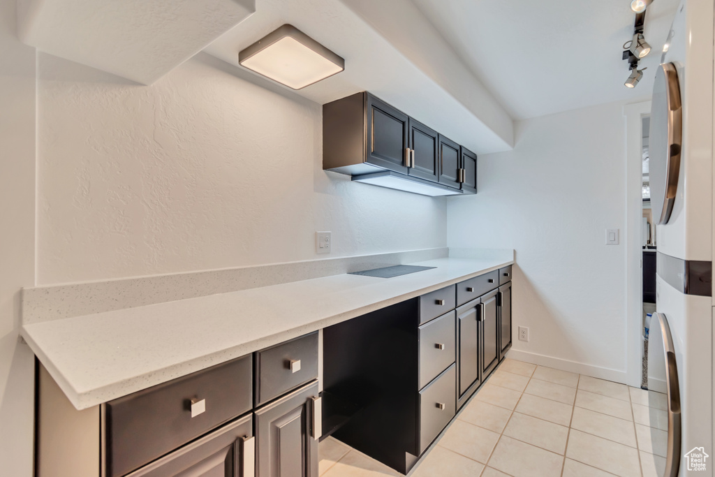 Kitchen with light tile patterned flooring, light countertops, and baseboards