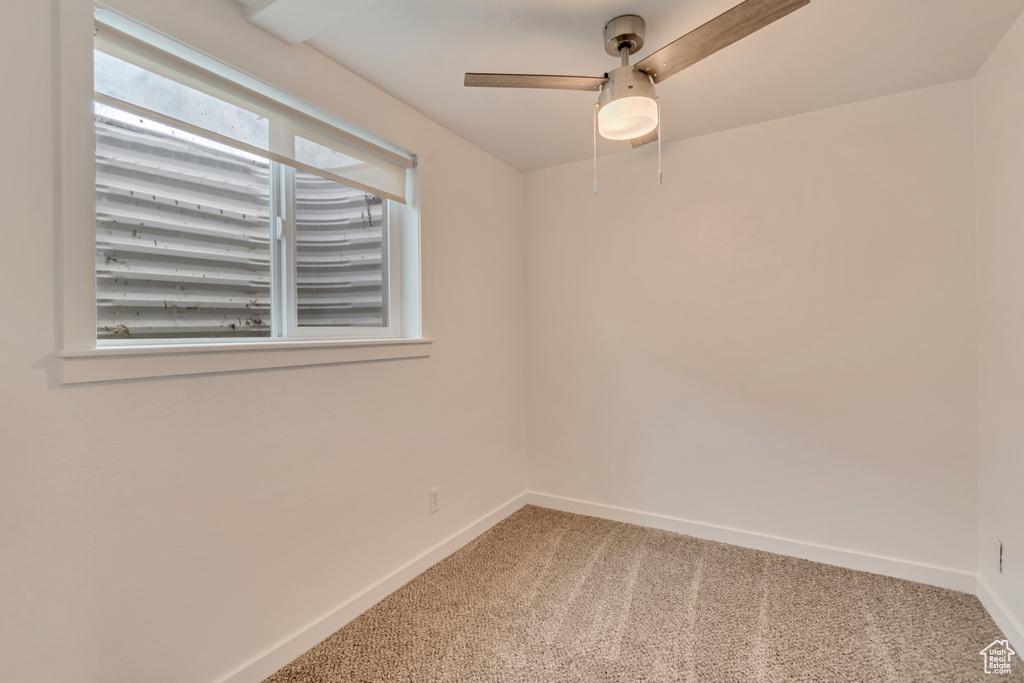 Carpeted spare room with baseboards and a ceiling fan