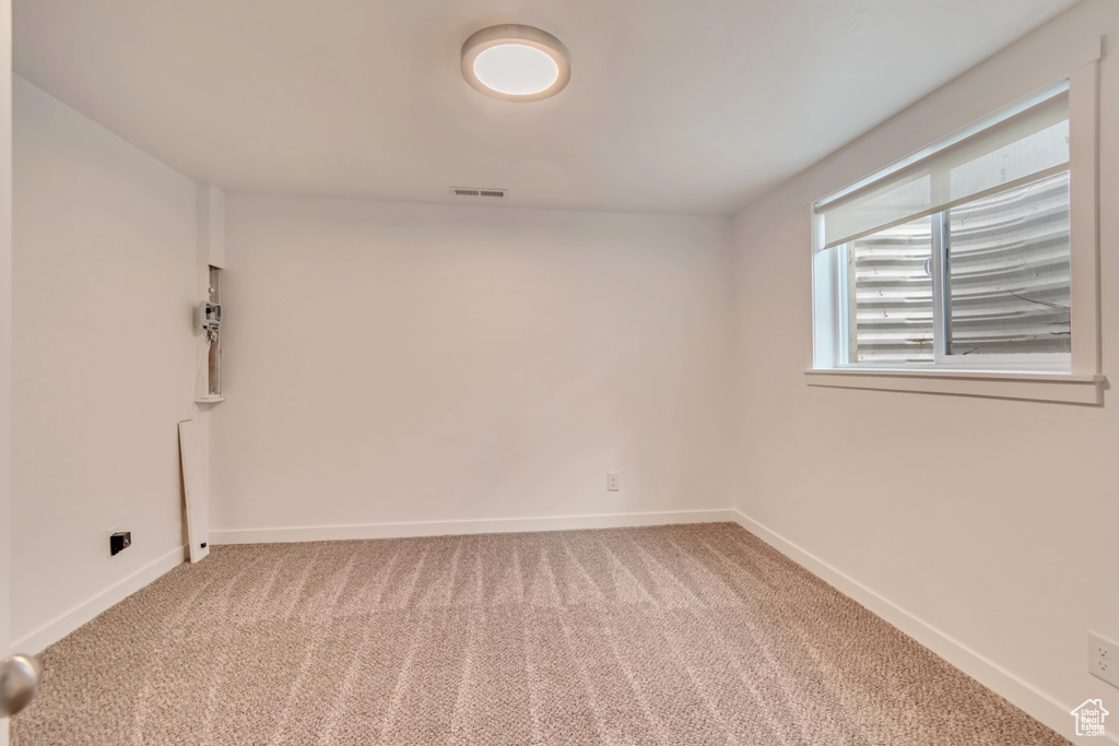 Carpeted spare room featuring baseboards