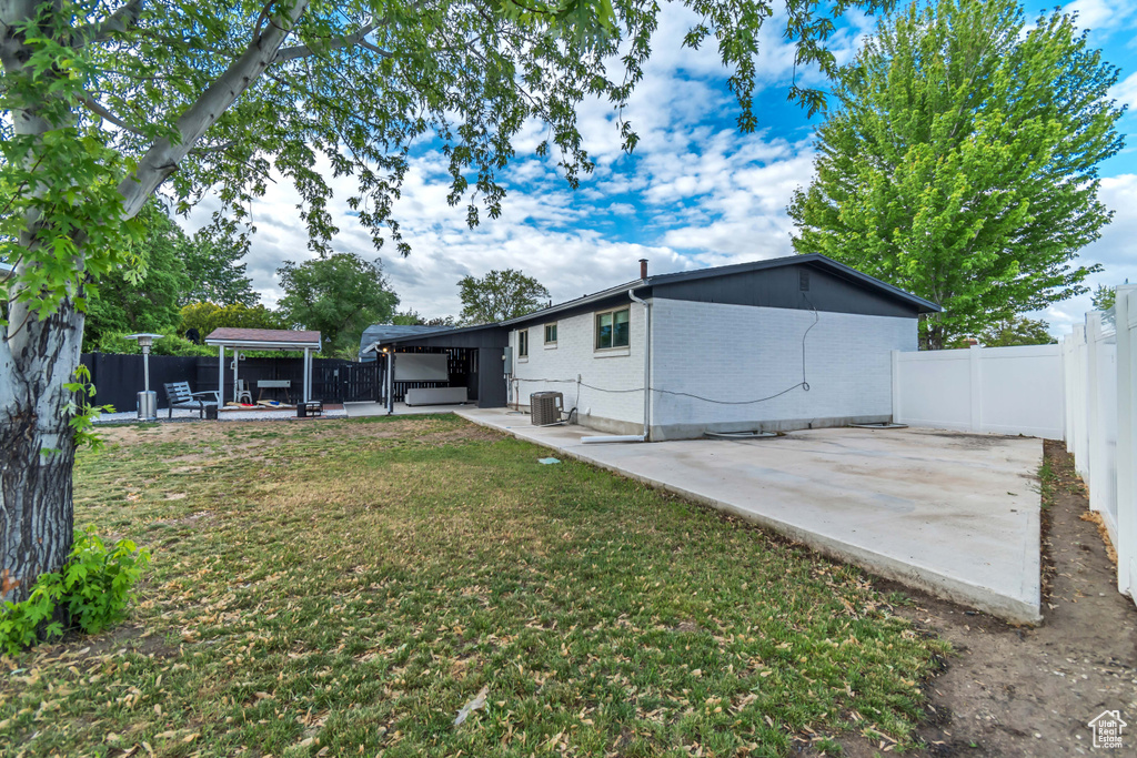 View of yard featuring a patio area, cooling unit, a hot tub, and a gazebo