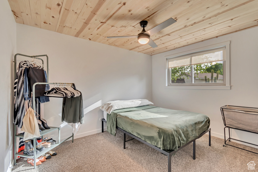 Bedroom with wooden ceiling, carpet floors, baseboards, and ceiling fan