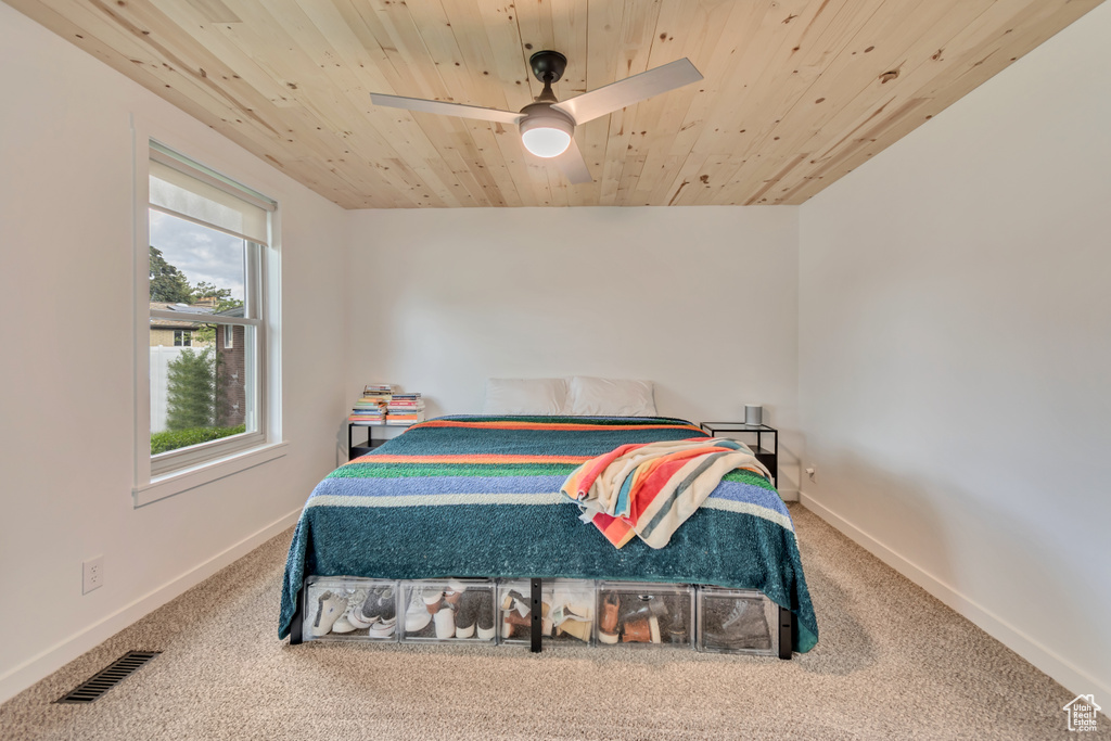 Carpeted bedroom featuring wooden ceiling, baseboards, and ceiling fan
