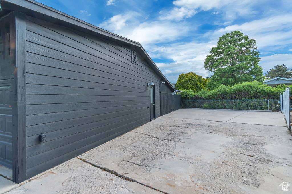 View of side of home featuring fence and a patio area