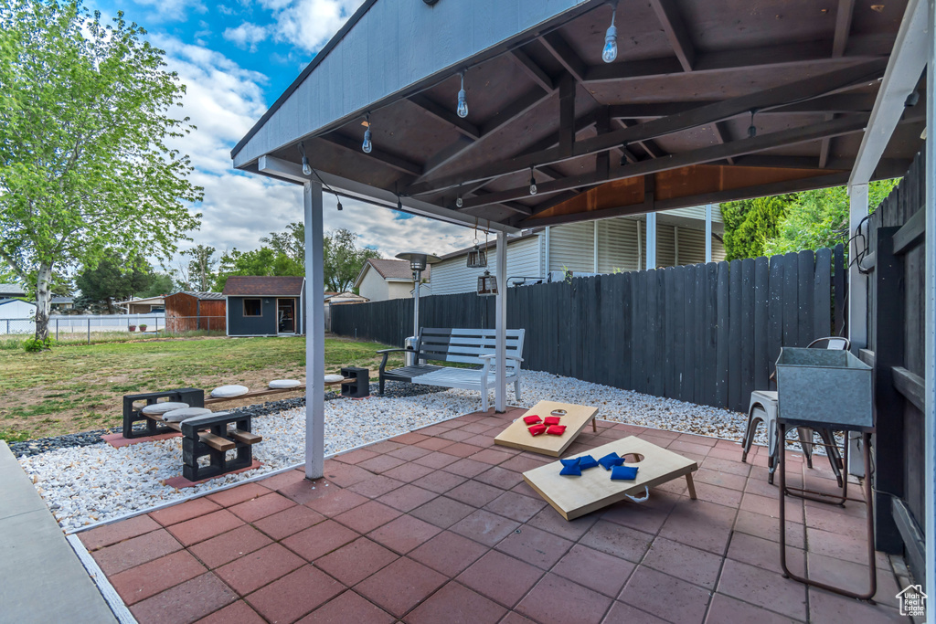 View of patio / terrace featuring an outdoor structure, a storage shed, and a fire pit