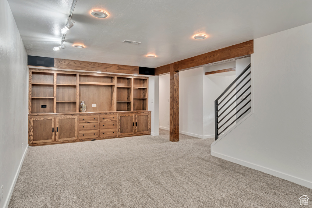Unfurnished living room with carpet flooring, stairway, and baseboards