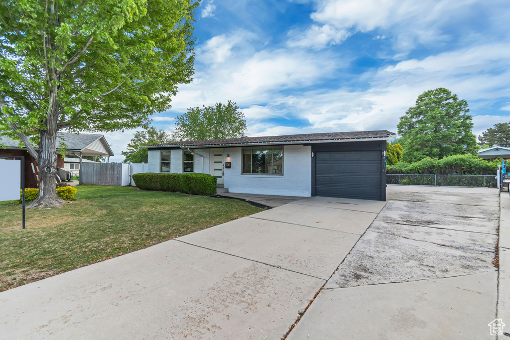 Ranch-style home with driveway, an attached garage, and brick siding