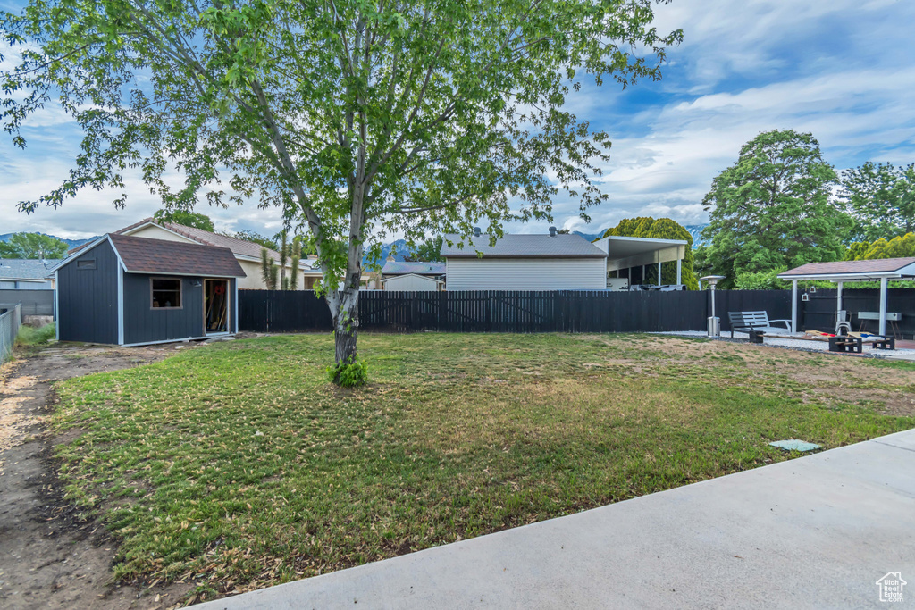 View of yard with an outdoor structure and a storage shed