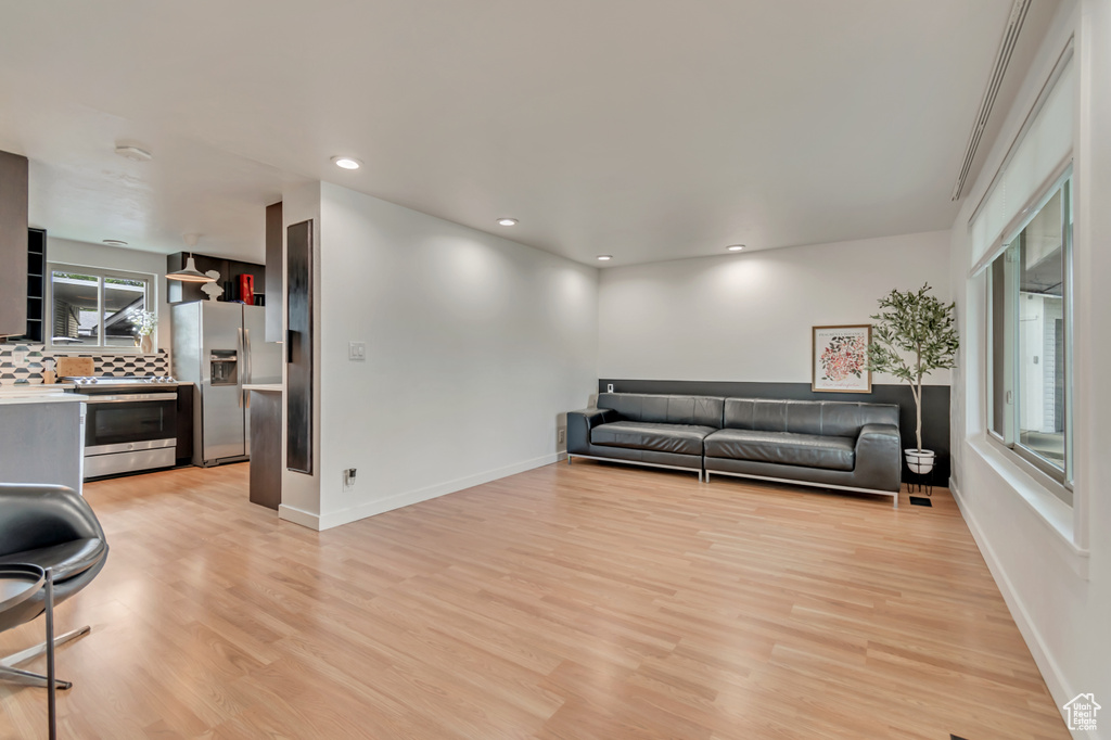 Living room featuring light wood-type flooring, recessed lighting, and baseboards