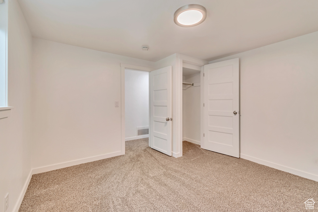 Unfurnished bedroom with carpet floors, baseboards, and a closet