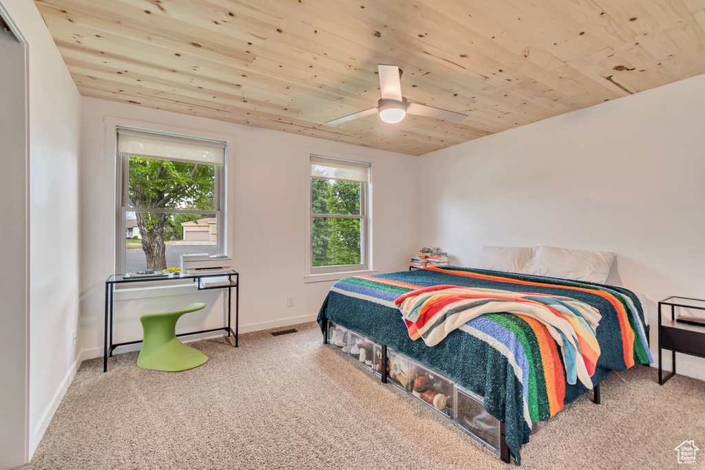 Carpeted bedroom featuring wood ceiling, baseboards, and ceiling fan
