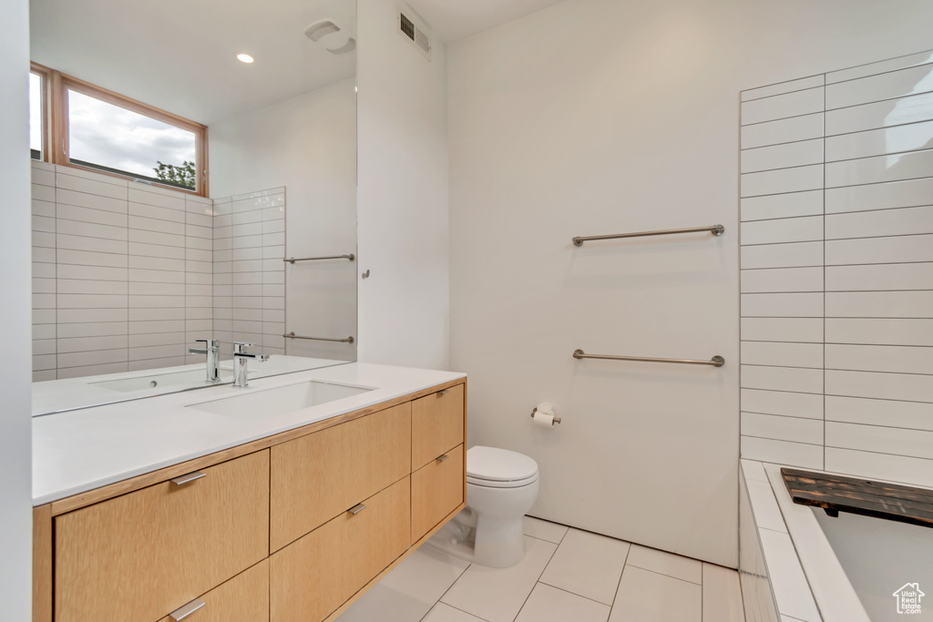 Bathroom featuring toilet, tile patterned flooring, and vanity