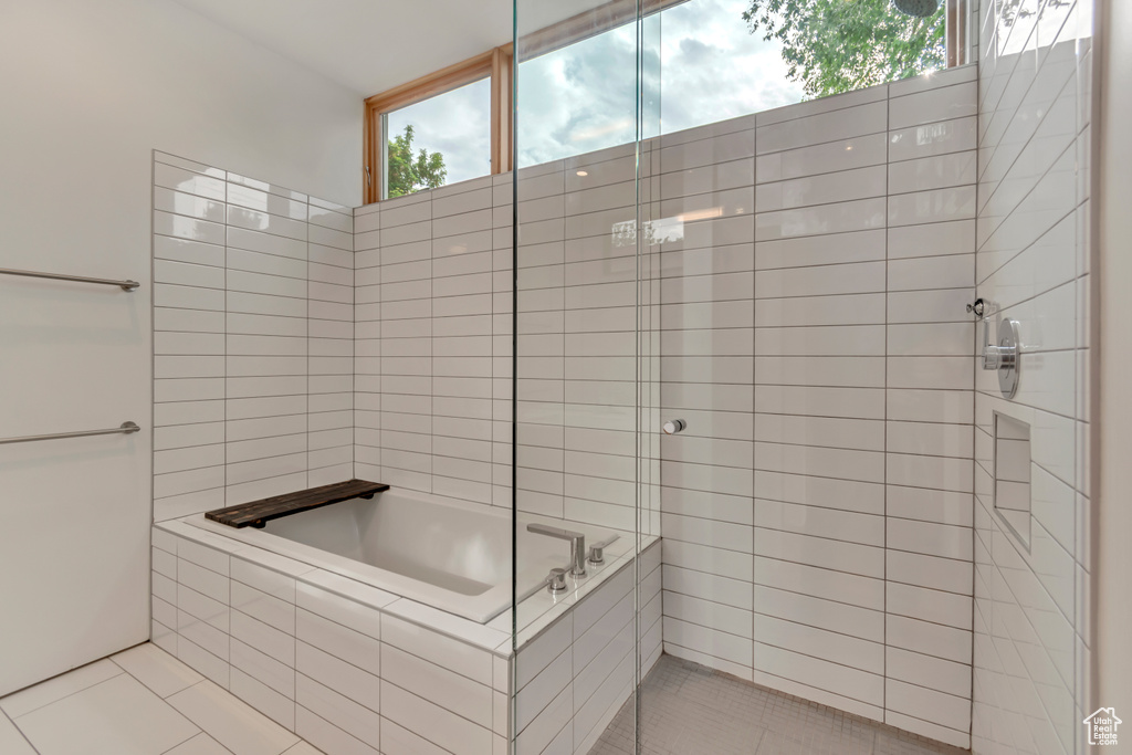 Bathroom featuring tile patterned flooring, tiled shower, and a bath