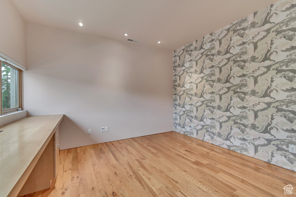 Empty room featuring light wood-type flooring and recessed lighting