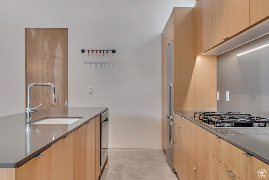 Kitchen featuring a sink, modern cabinets, gas cooktop, and light brown cabinets