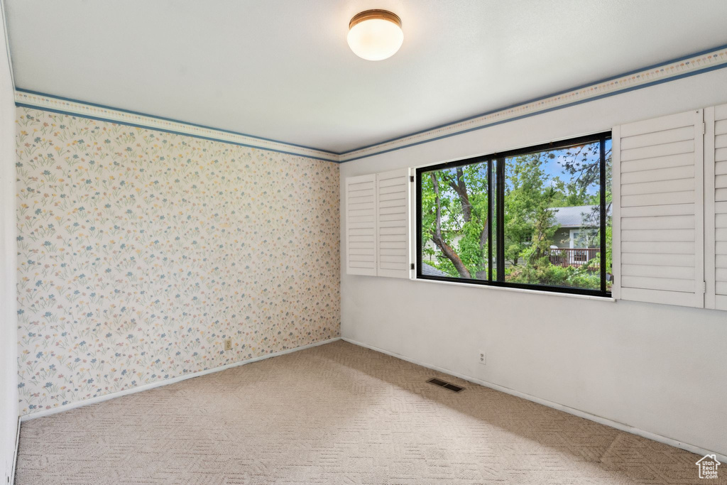 Unfurnished room with carpet flooring and wallpapered walls