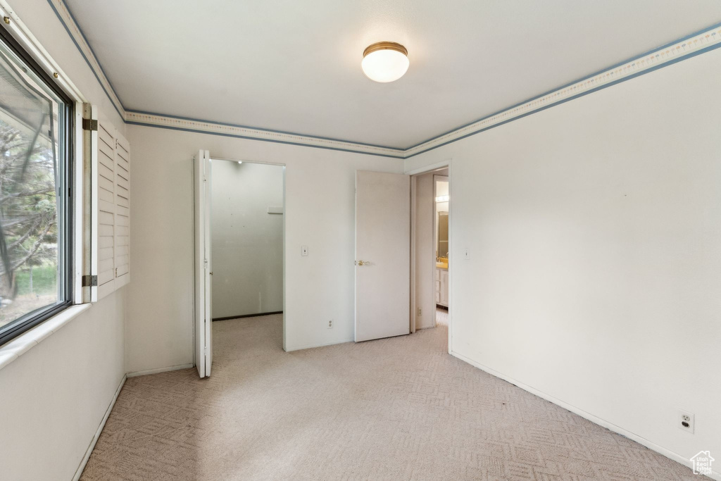 Unfurnished bedroom with multiple windows and light colored carpet