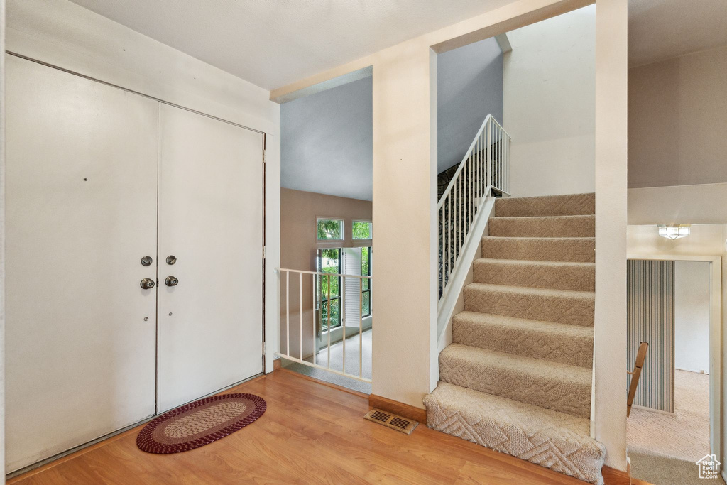 Foyer entrance with wood finished floors and stairs