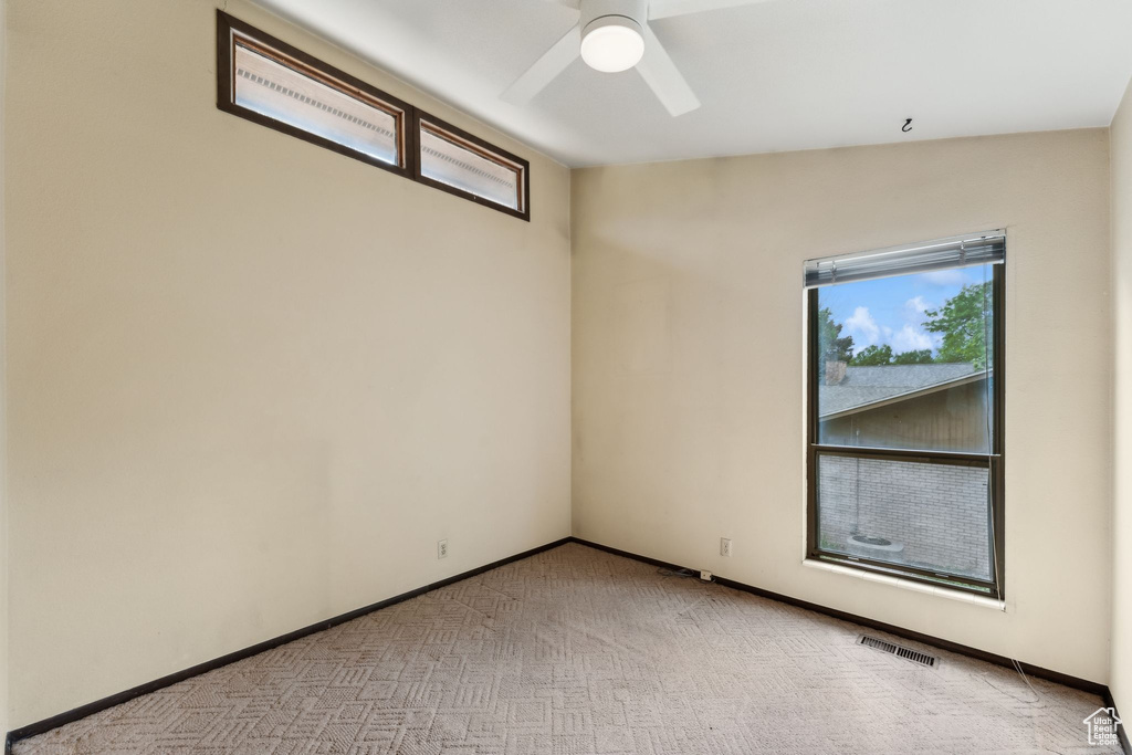 Unfurnished room with a ceiling fan, carpet, and baseboards