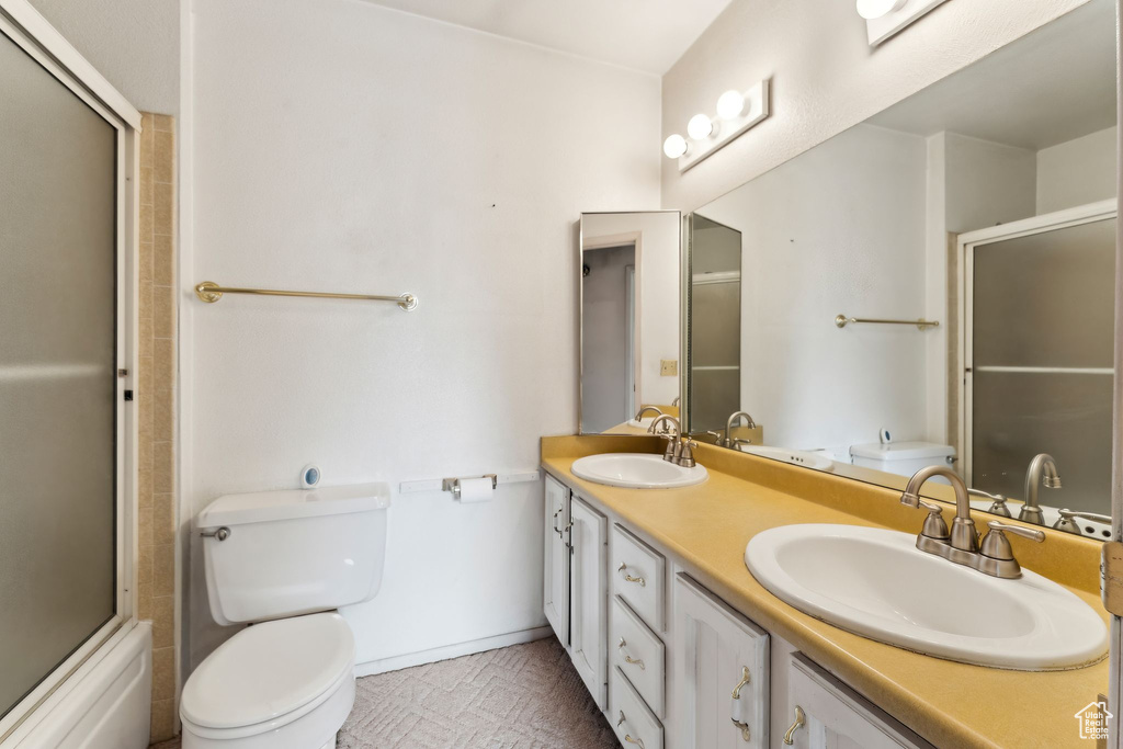 Full bathroom with toilet and double vanity