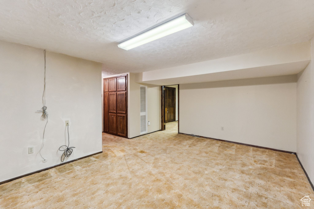 Finished below grade area with carpet and a textured ceiling