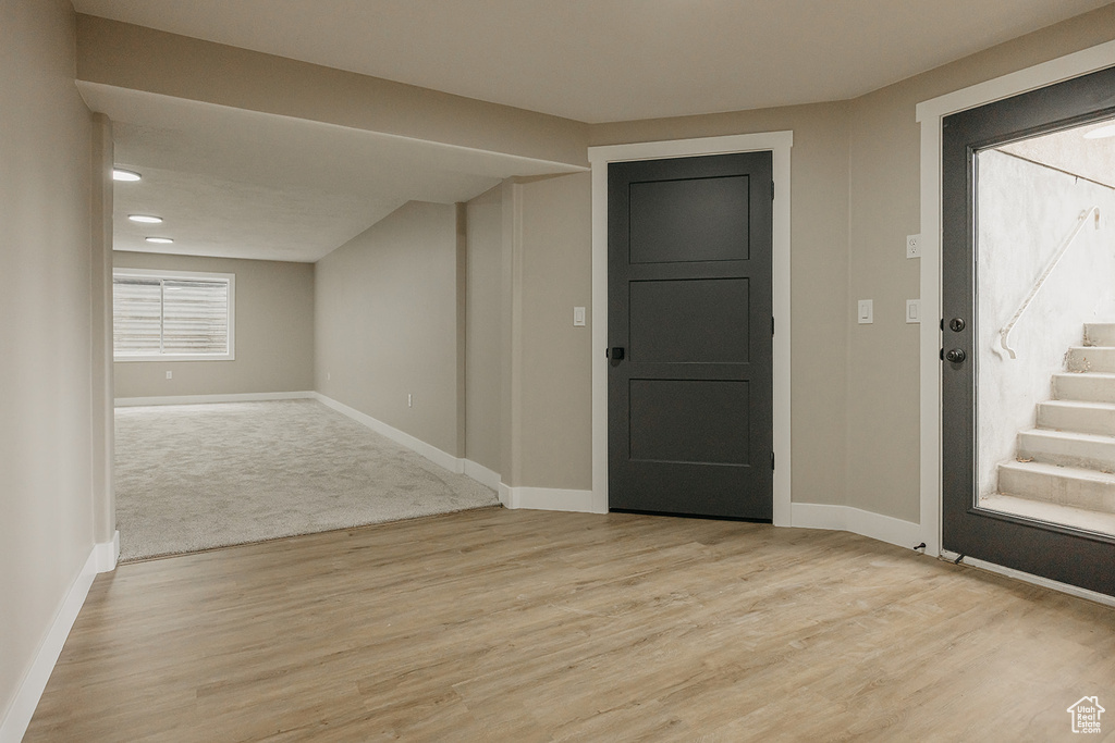 Foyer featuring light wood-style flooring, baseboards, and stairs