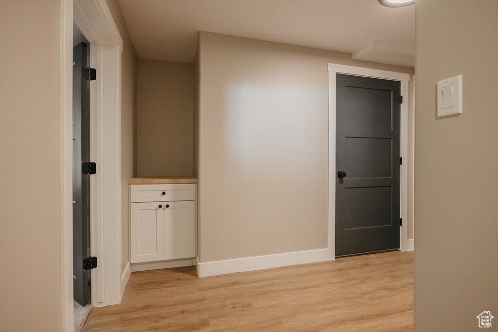 Hall with light wood-style floors and baseboards
