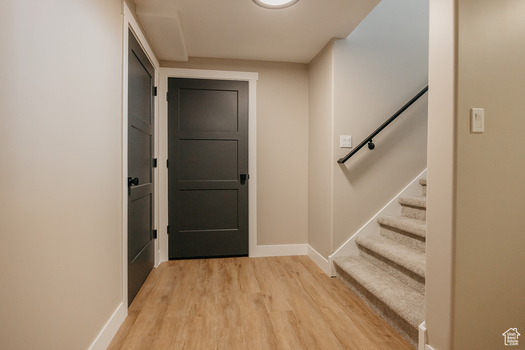 Entryway with light wood-style flooring, baseboards, and stairs