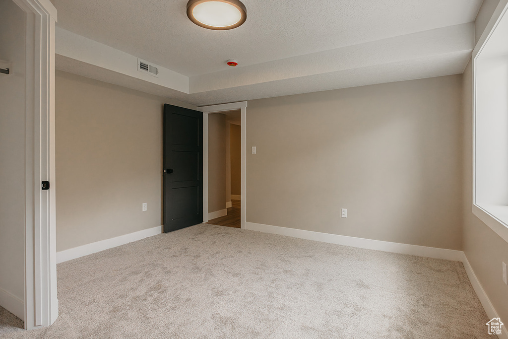 Unfurnished bedroom featuring carpet flooring, baseboards, and a textured ceiling
