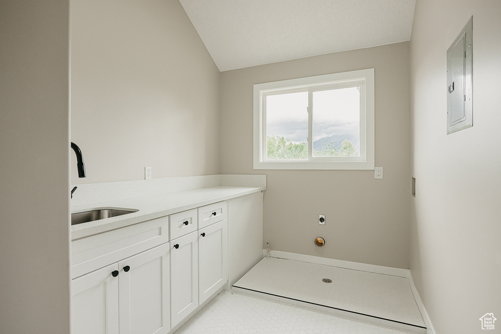 Laundry area featuring electric panel and a sink