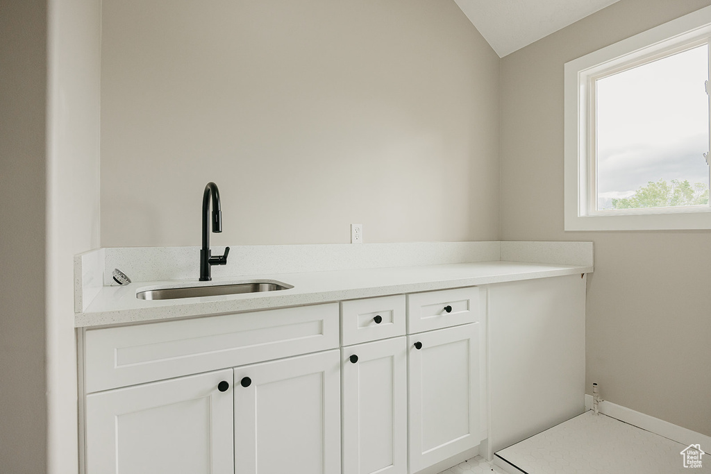 Bathroom featuring a sink and vaulted ceiling