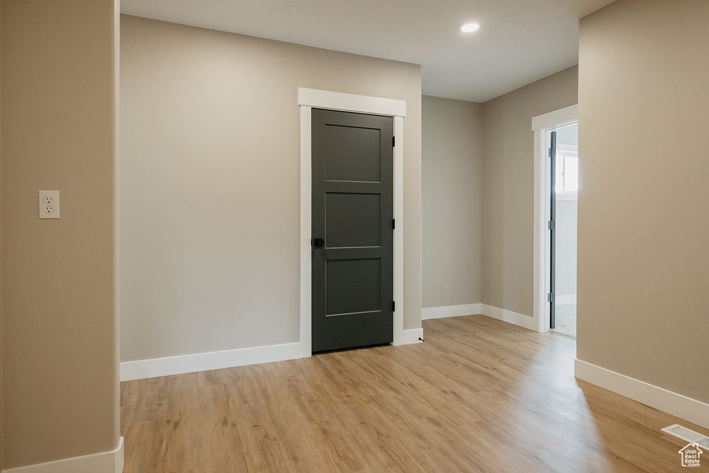 Empty room with light wood-style floors, baseboards, and recessed lighting