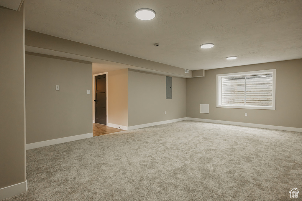 Below grade area with carpet, baseboards, electric panel, and recessed lighting