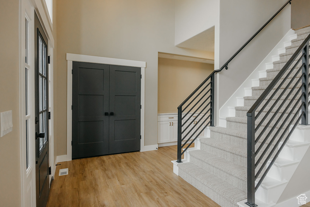 Foyer entrance featuring stairs, light wood-style flooring, and baseboards